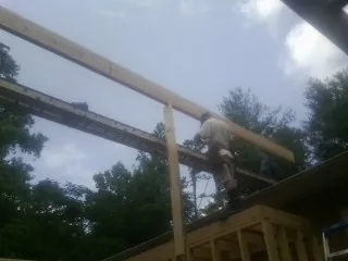 Carpenter setting a ridge beam over a new addition frame — Ice Dam Removal by Roofing Brothers in Brackenridge