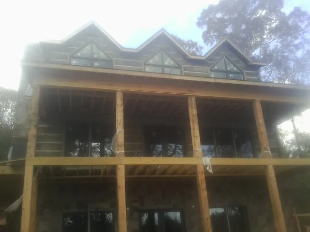 Dormers and porch framing on a large log home under construction — Roof Coating work by our crew in Brackenridge