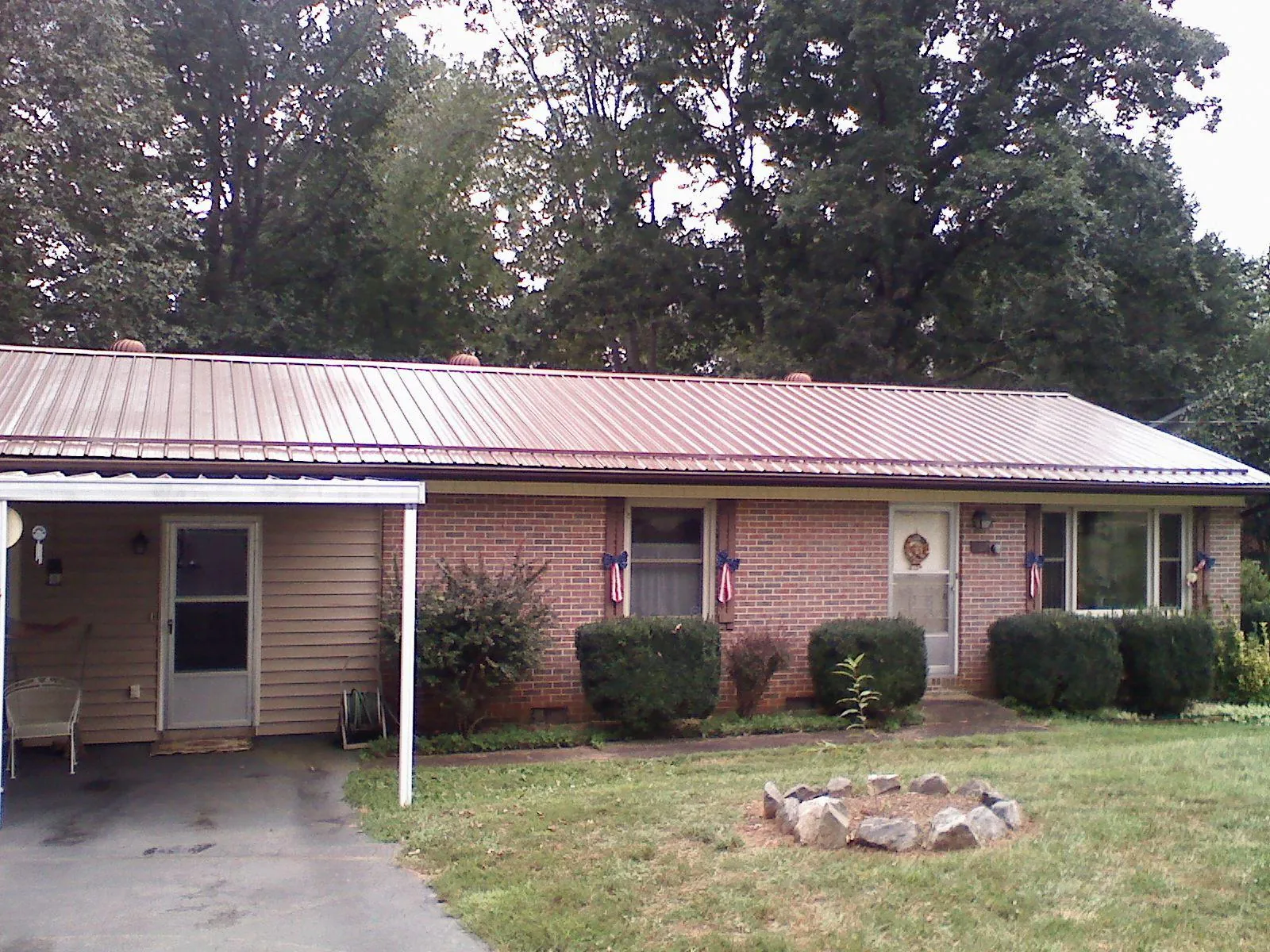 Bronze metal roof and carport on a brick ranch home — Roof Repair work by our crew in Brackenridge