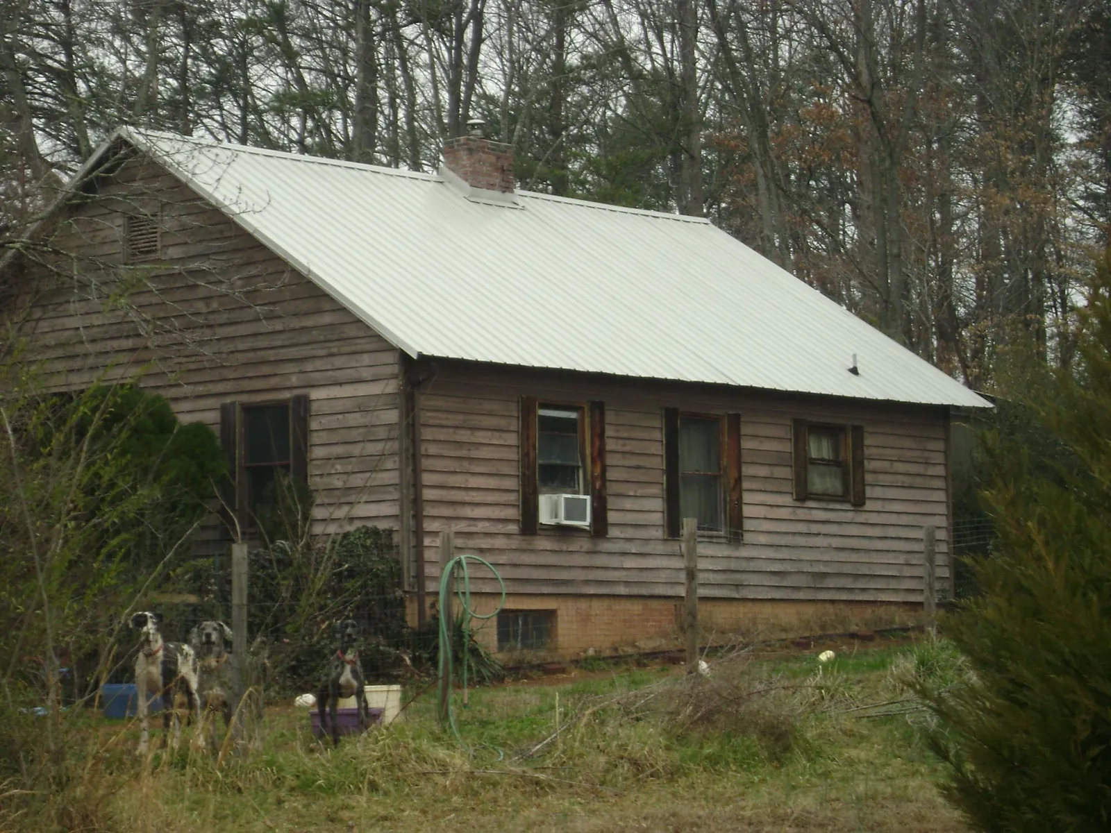 White metal roof on an old wood sided farmhouse, from a Metal Roof Installation job in Brackenridge